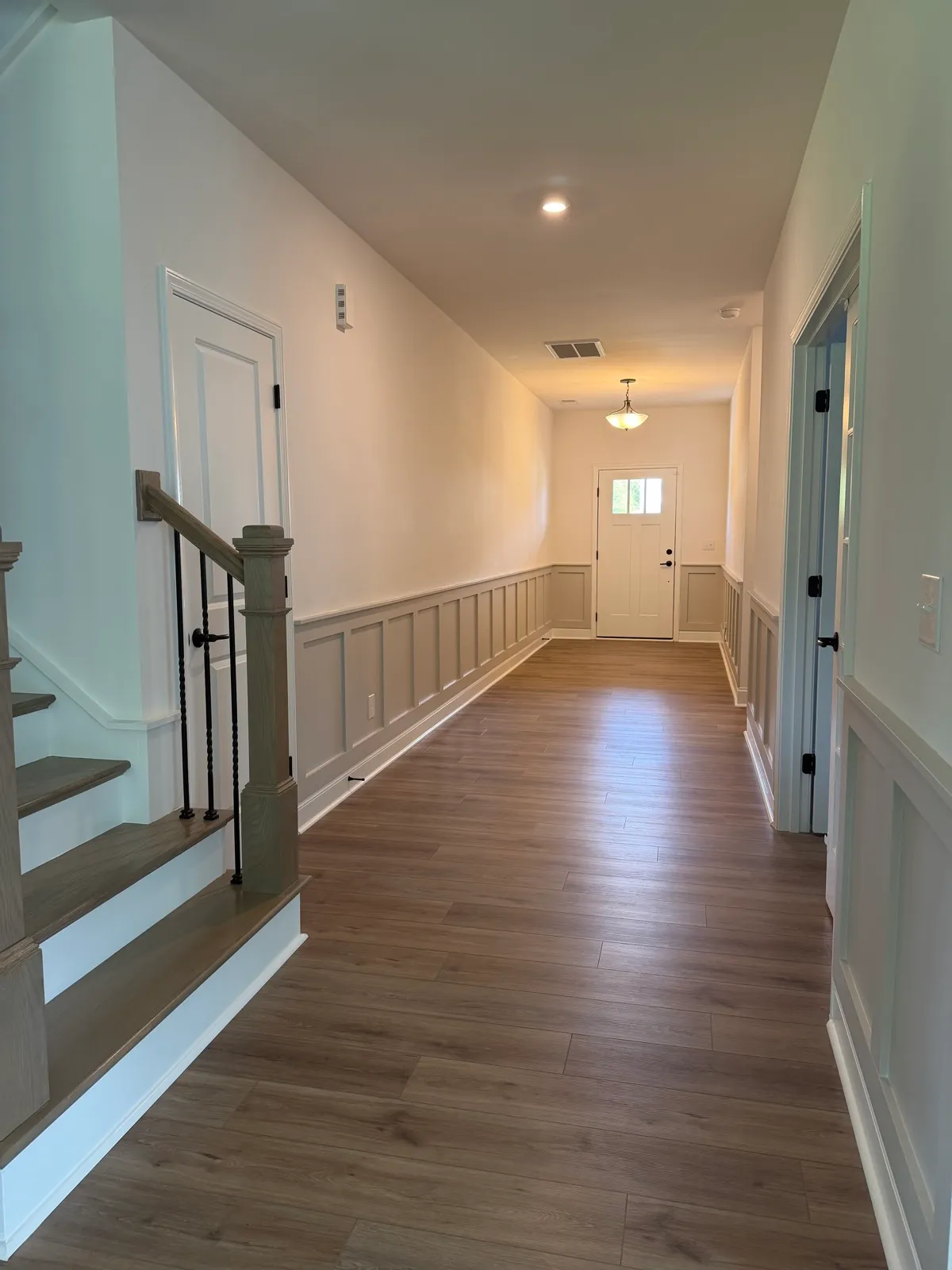 Wainscoting along a long hallway beside the staircase